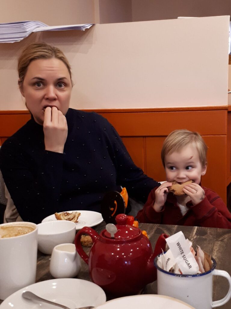 Jessie Hewitson and her son sharing a snack in a cafe